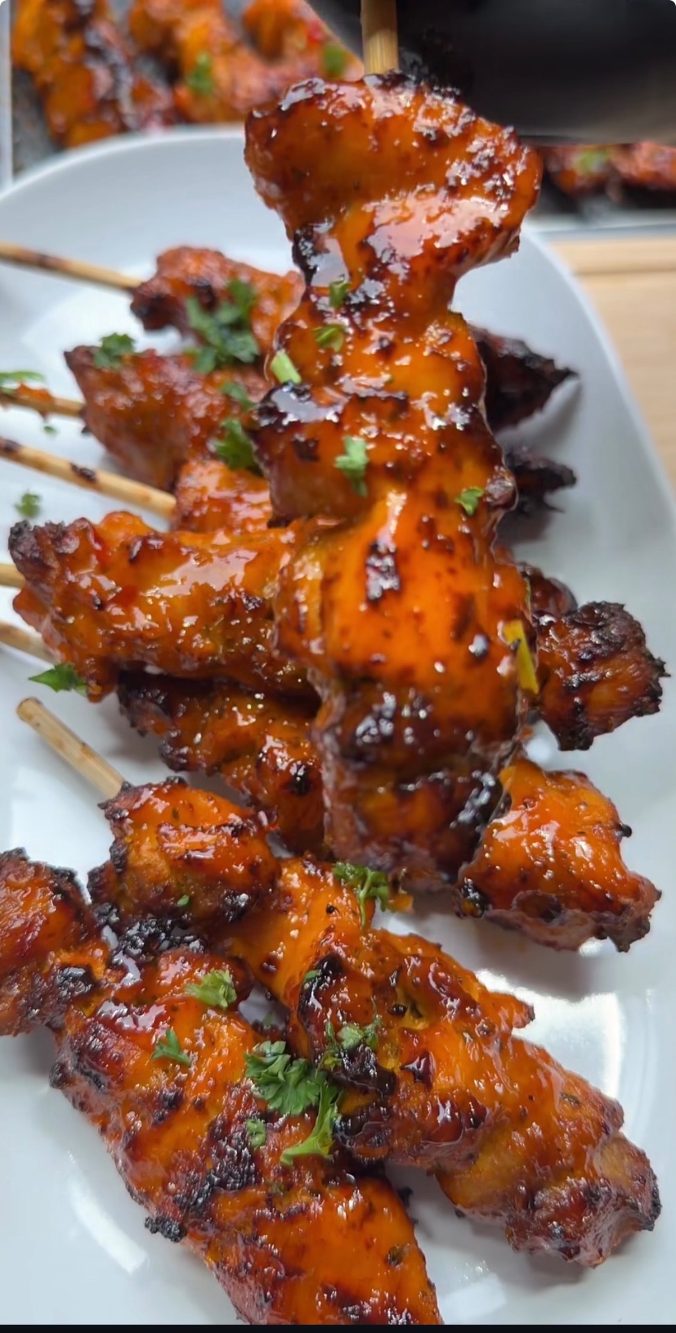 Glazed grilled chicken skewers plated with fresh herbs